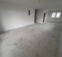 An unfurnished room with white walls and a concrete floor in a family house.