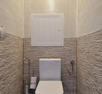 Bathroom with toilet and tiles in a 2-room apartment, with ceramic flooring.