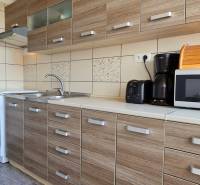 A kitchen in a 2-room apartment with a wooden decor floor and appliances.