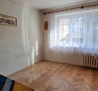 A room with a window and a wooden decor floor in a 3-room apartment.