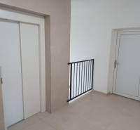 Hallway with an elevator and white doors in a 2-room apartment.