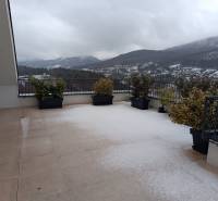 A snowy terrace in Nová Baňa on Pod sekvojou Street with a mountain view.