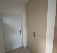 Entrance hallway with white doors and a large wardrobe in a 2-room apartment.