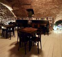 Interior of a gastro space with stone walls, wooden decor flooring, library.