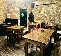 Gastro premises with stone walls, a piano, and a floor with a wooden decor.