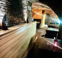 Stone walls and arches in dining areas with wood-patterned flooring.