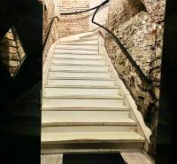 Stone stairs leading upwards in historical gastro premises with a wooden decor floor.