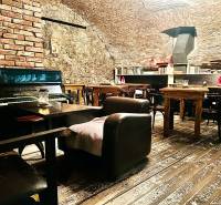 Interior with brick walls, piano, and bookshelf, wooden decor flooring, gastro spaces.