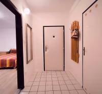 Hallway in a 2-room apartment with white walls, tiles, and a mirror.
