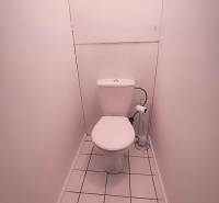 White toilets with a tiled floor in a 2-room apartment.