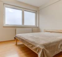 A bedroom in a 2-room apartment with a double bed and a floor with a wood decor.
