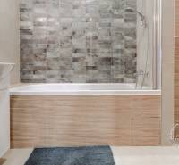 Bathroom in a 2-room apartment with a bathtub, sink, and toilet, tiled.