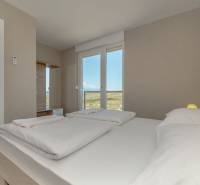 Bright bedroom with a double bed and access to a bathroom in the Holiday Apartment.