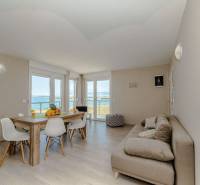 Recreational apartment with wooden decor flooring, dining table, and sea view.