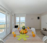 Dining table in a Holiday Apartment with a sea view through large windows.