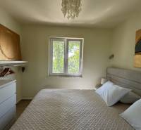 A bedroom in a family house with art on the walls and a pendant light.