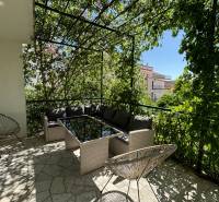 The terrace of a family house in Čiovo with comfortable seating and greenery for a pleasant sitting experience.