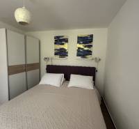 A bedroom in a family house with a double bed, a wardrobe, and wall decorations.