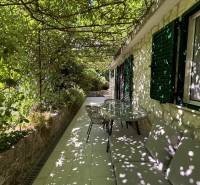A covered terrace of a family house in Čiovo with climbing plants and outdoor seating.