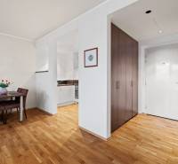 Interior of a 2-room apartment with dining area, kitchen, and entrance, floor with wooden decor.