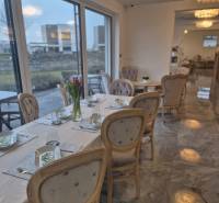 Cozy dining spaces with elegant table settings, flowers, and large windows.