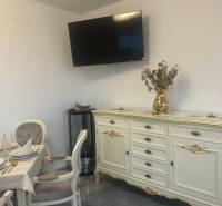 Elegantly furnished interior of dining spaces with a television on the wall and decorated furniture.