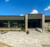 On Tatranská Street, there is a building with a garden, benches, and an access road.