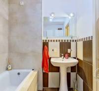 Bathroom in a 3-room apartment with a bathtub, sink, and mirror.