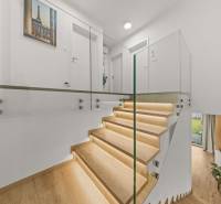 Glass railing and stairs with wood-decor flooring in a 4-room apartment.