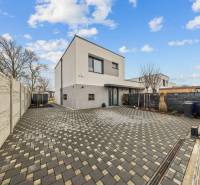 A family house on Topoľová Street in Rovinka with a paved courtyard and fencing.