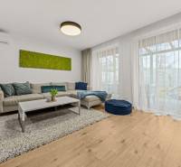 Living room in a 4-room apartment with a comfortable sofa and a floor with a wooden decor.