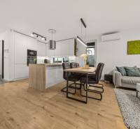 The kitchen in a 4-room apartment with a wooden decor floor and a dining table.
