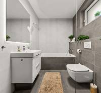 Bathroom in a 4-room apartment with a bathtub, white sink, and plants.