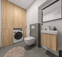A bathroom with a wall-hung toilet, sink, and washing machine with cabinets in a 4-room apartment.