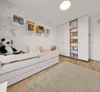 Children's room in a 4-room apartment with a bed, toys, and books, floor with wooden decor.