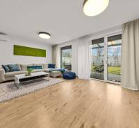 Living room with a sofa, glass doors, and a wooden decor floor in a 4-room apartment.