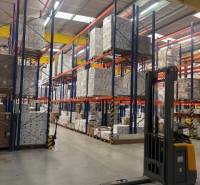 In warehouses and halls, we see tall racks with pallets and a forklift.