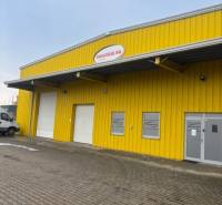 Yellow warehouse and hall building on Poľná cesta in Senec with entrance gates.