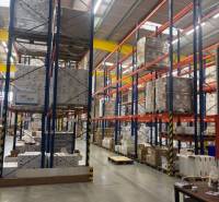 Shelves in warehouses and halls full of stored goods on pallets.