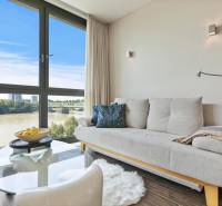 Living room in a two-room apartment with a sofa and a large window with a view.