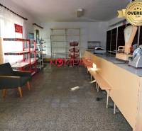 Interior of commercial premises with a counter, shelves, and an armchair.