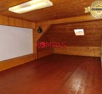 Attic space with wooden decor in commercial premises, with a small skylight.