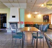 Commercial space with stylish chairs, table, and fireplace, suitable for events.