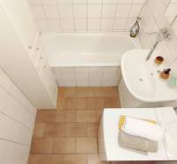 Bathroom in a 2-room apartment with a bathtub, sink, and washing machine.