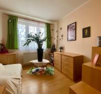 A room in a 3-room apartment with decorations, wooden dressers, and a wooden decor floor.