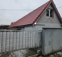 A family house in Tornyosnémeti with a red roof and a gray fence.