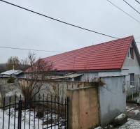 A family house in Tornyosnémeti with a red roof and a snow-covered yard.