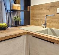 Kitchen unit in a one-room apartment with a sink and a wooden decor floor.