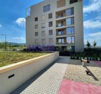 Residential complex on Zdenka Schelingová Street in Bratislava, Devínska Nová Ves, with greenery and a playground.