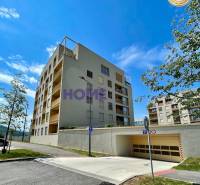 Apartment building on Zdenka Schelingová Street in Bratislava, Devínska Nová Ves, with a garage entrance.
